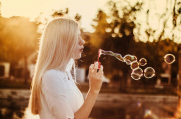 woman-blowing-bubbles-during-sunset-alkJl-mokOY