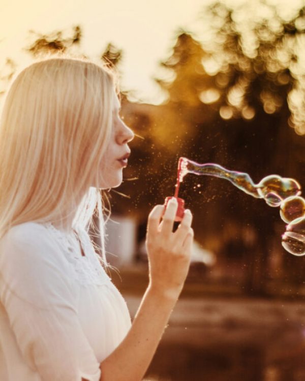 woman-blowing-bubbles-during-sunset-alkJl-mokOY